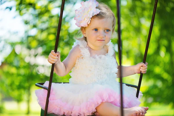 Cute little girl in tutu swinging — Stock Photo, Image