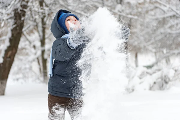 Kleiner Junge mit Schaufel spielt im Schnee — Stockfoto