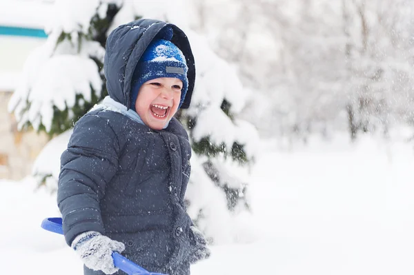 Little boy with shovel playing in snow — Stock Photo, Image