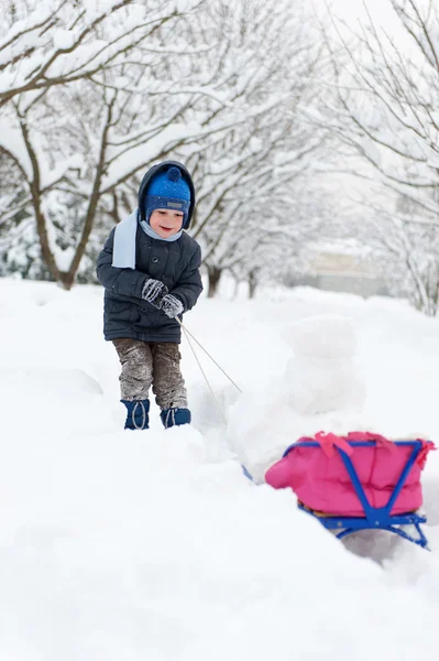 雪橇在雪森林中的小男孩 — 图库照片