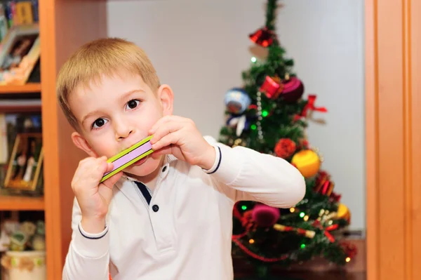 Mignon petit garçon jouer sur harmonica — Photo