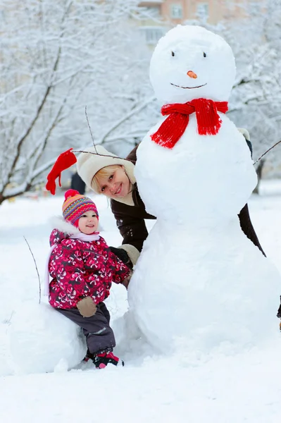 Großmutter mit Enkelin spielt im Schnee — Stockfoto