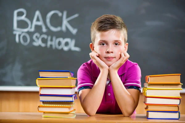 Cute pupil with books in classroom — Stock Photo, Image
