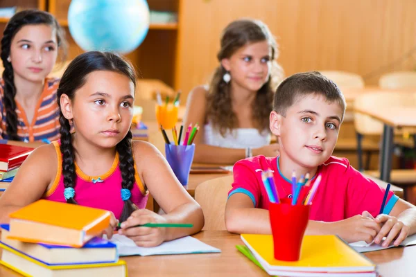 Bonitos alunos em sala de aula na escola — Fotografia de Stock