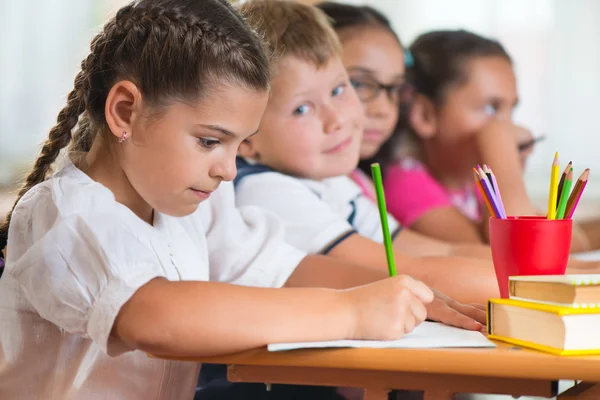 Quatre élèves assidus qui étudient en classe — Photo