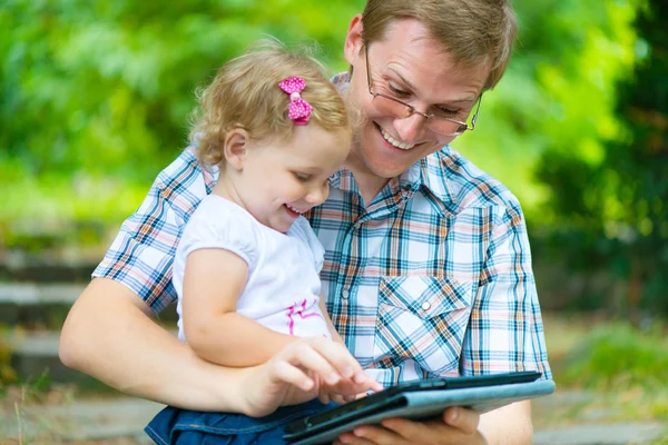 Joven padre y pequeña hija leyendo — Foto de Stock