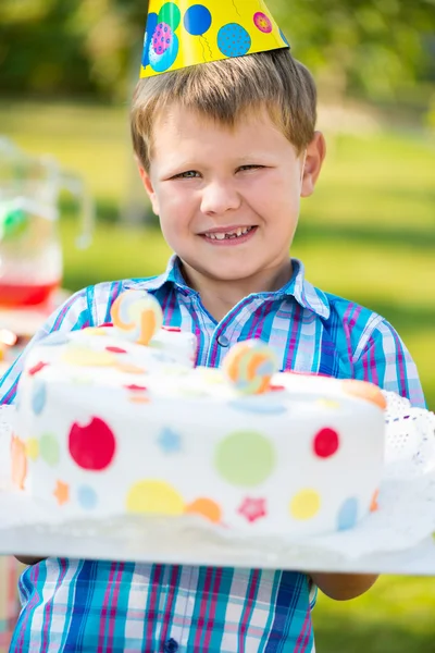 Menino feliz segurando bolo na festa de aniversário — Fotografia de Stock