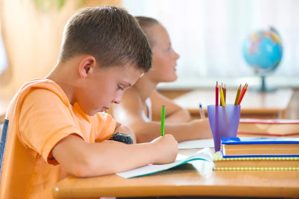 Smart skolpojke studerar i klassrummet — Stockfoto