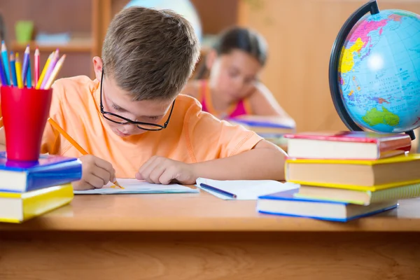 Clever schoolboy studying in classroom — Stock Photo, Image