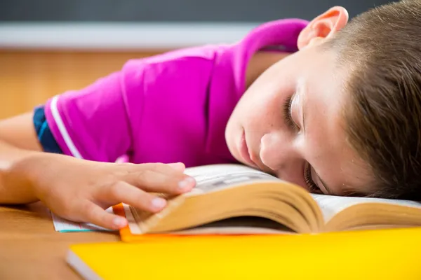 Unavený školák, spaní na knihu — Stock fotografie
