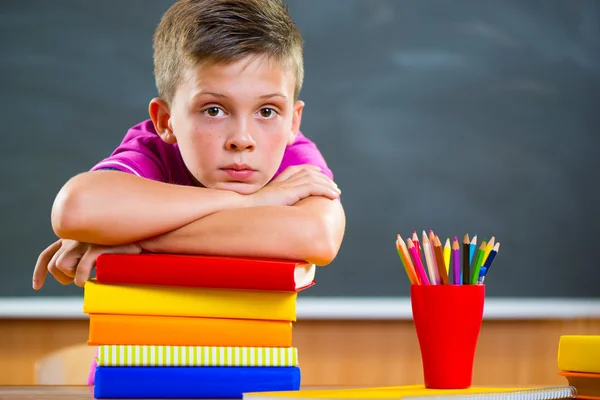 Entzückender Schuljunge mit einem Stapel Bücher — Stockfoto