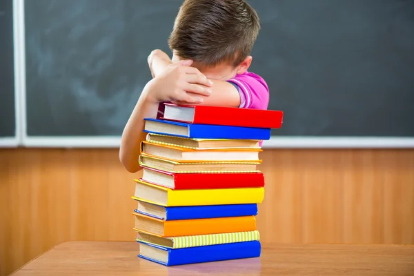 Entzückender Schuljunge mit einem Stapel Bücher — Stockfoto