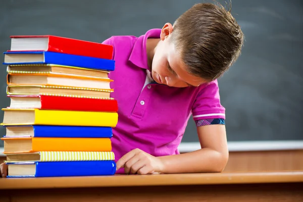 Entzückender Schuljunge mit einem Stapel Bücher — Stockfoto