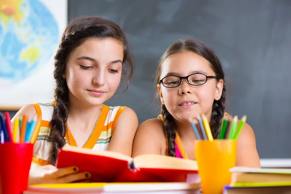 Portrait of two beautiful schoolgirl in classroom Stock Picture