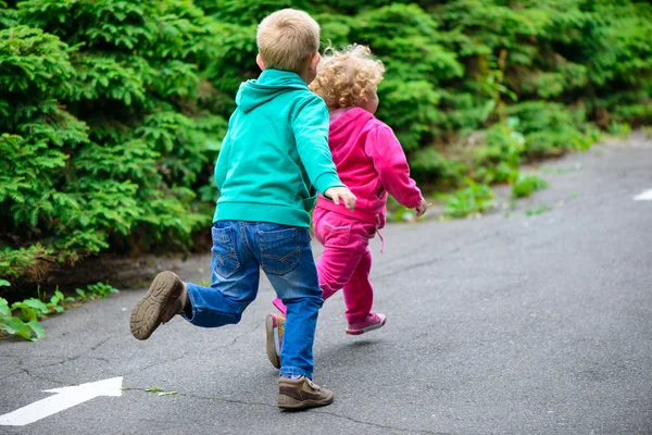 Hermano pequeño y hermana corriendo — Foto de Stock