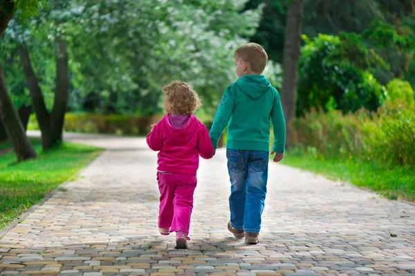 Little brother and sister walking by footpath — Stock Photo, Image