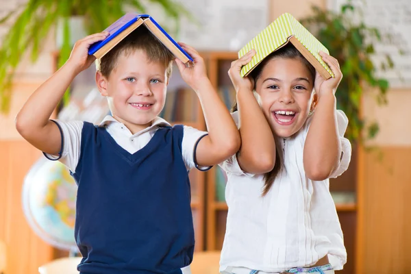 Two happy schoolchildren have fun in classroom — Stock Photo, Image