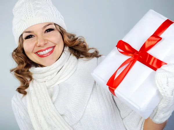 Beautiful young woman in white hat holding Christmas present — Stock Photo, Image