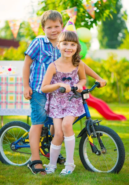 Two happy children sitting on bicycle — Stock Photo, Image