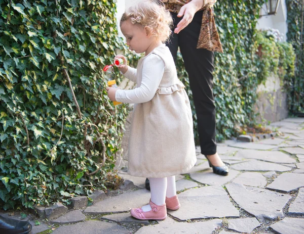 Nettes kleines Mädchen bläst Seifenblasen — Stockfoto