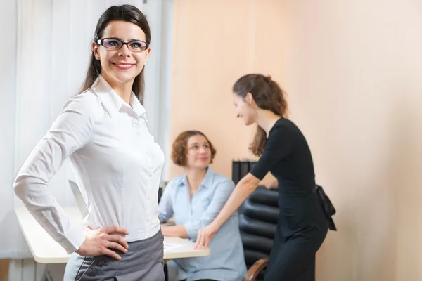 Geschäftsfrau steht mit ihren Mitarbeitern im Hintergrund — Stockfoto