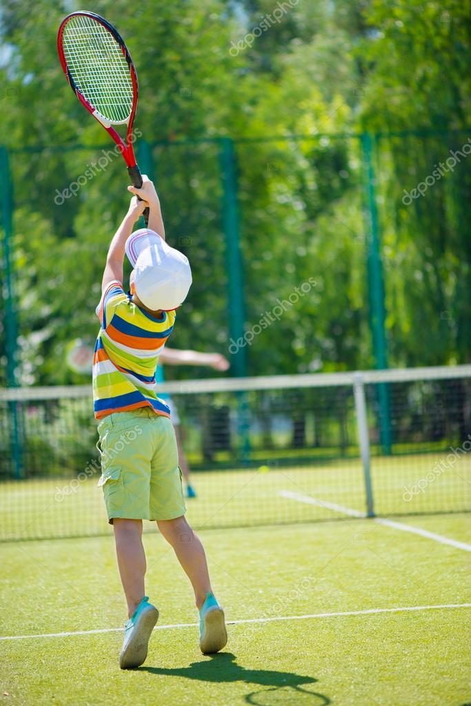 little boy playing tennis