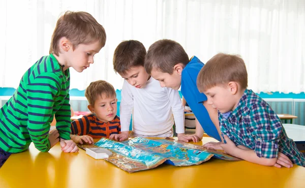 Mignons enfants d'âge préscolaire plaçant jeu sur la table — Photo