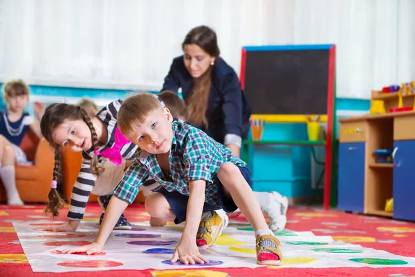 Cute toddlers playing in twister game — Stock Photo, Image