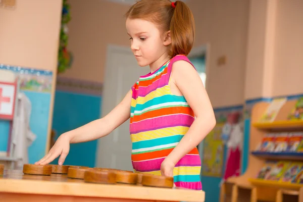 Menina bonito jogar damas na creche — Fotografia de Stock