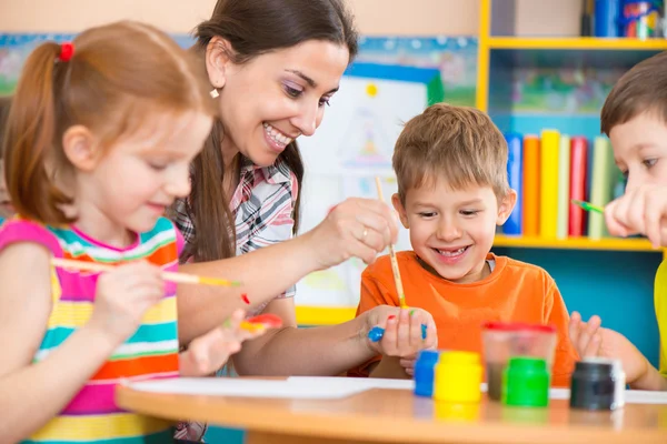 Crianças bonitos desenho com professor na aula pré-escolar — Fotografia de Stock