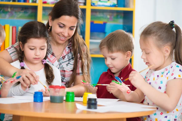 Crianças bonitos desenho com professor na aula pré-escolar — Fotografia de Stock