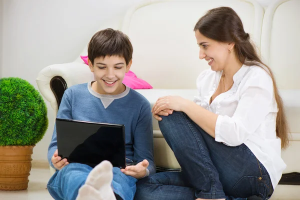 Tiener zoon met jonge moeder met laptop — Stockfoto