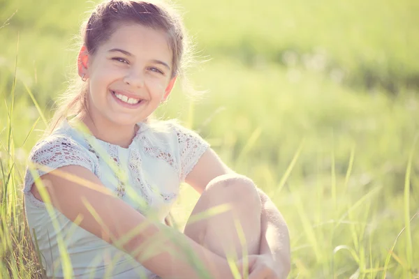 Счастливая девушка отдыхает на солнечном лугу — стоковое фото