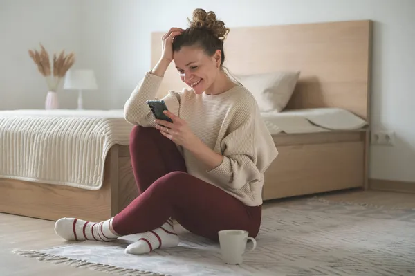 Feliz Mulher Bonita Sentada Com Celular Chão Quarto Casa Aconchegante — Fotografia de Stock