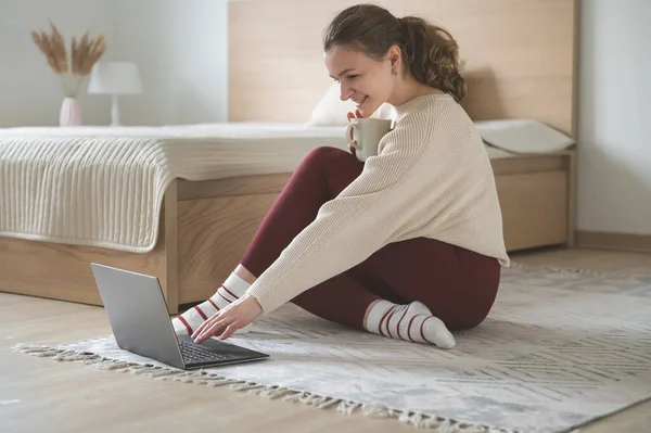 Csinos Fiatal Beszélgetni Laptop Tea Csésze Padlón Kényelmes Otthon — Stock Fotó