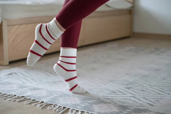 在舒适的家 穿着条纹保暖长袜的女子纤脚的近照 — 图库照片