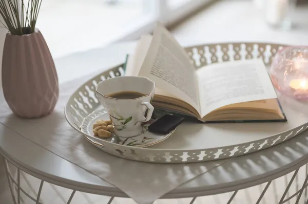黒コーヒーとダークチョコレートと本とスタイリッシュな白いトレイの写真 背景に居心地の良い椅子 — ストック写真