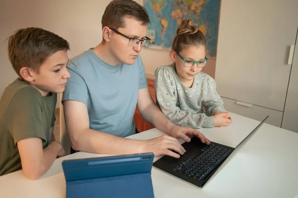 快乐的年轻父亲在家里用笔记本电脑和十几岁的孩子一起学习 — 图库照片