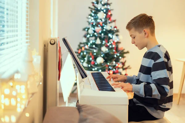 Tennage Ragazzo Pratica Treccia Pianoforte Casa Con Albero Capodanno Sullo — Foto Stock