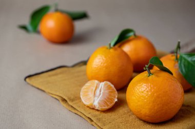 Kışın portakal peçetesinde taze Clementine mandalinalarının yakın plan fotoğrafı.