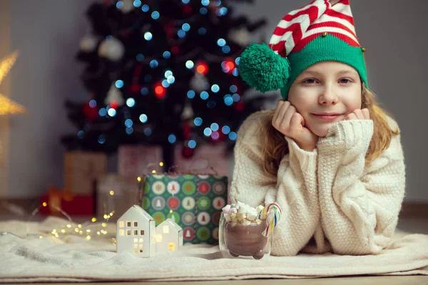 Linda Niña Con Sombrero Divertido Sentado Cerca Del Árbol Navidad —  Fotos de Stock