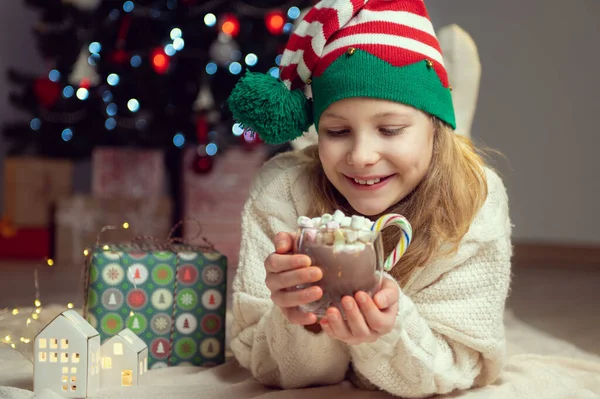 Pretty Little Girl Funny Hat Sitting Christmas Tree New Years 免版税图库照片
