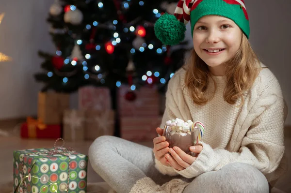 Pretty Little Girl Funny Hat Sitting Christmas Tree New Years 免版税图库照片