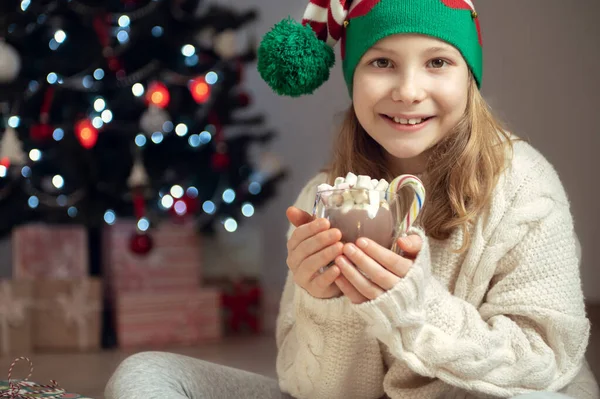 Mooi Klein Meisje Met Grappige Hoed Zitten Buurt Van Kerstboom — Stockfoto