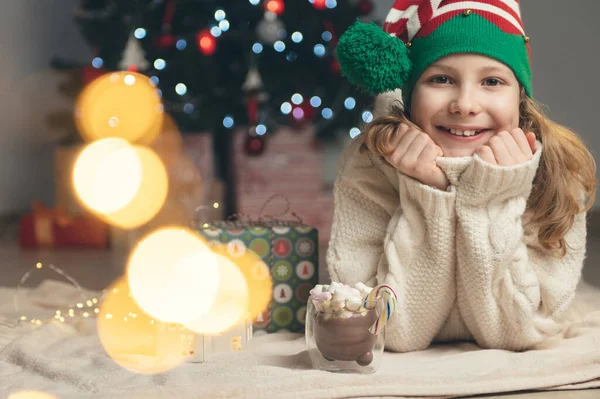 Söt Liten Flicka Med Rolig Hatt Sitter Nära Julgran Med — Stockfoto