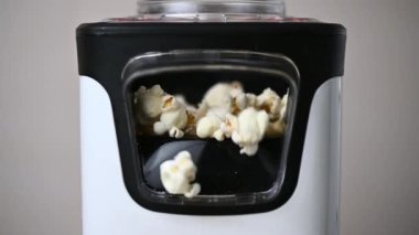 Slow motion closeup video of popcorn maker popping popcorn at home