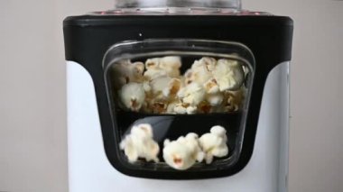Slow motion closeup video of popcorn maker popping popcorn at home