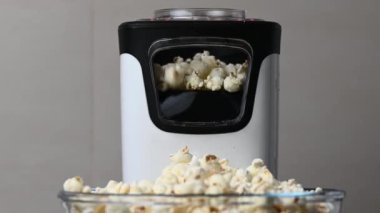 Slow motion 4K video of popcorn machine producing popcorn out of corn into bowl