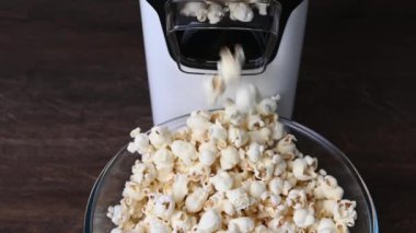 Slow motion 4K video of popcorn machine producing popcorn out of corn into bowl