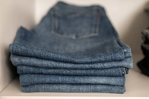 Close Foto Van Stapel Netjes Gevouwen Blauwe Jeans Plank Garderobe — Stockfoto